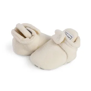 Close-up of soft off-white fleece baby walking shoes with warm lining for winter infants