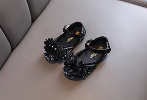 Close-up of black girls princess shoes with rhinestones and floral decoration