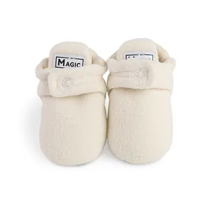 Cozy white fleece baby booties with adjustable velcro strap for newborn winter warmth.