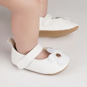 Nahaufnahme weißer Baby-Lauflernschuhe mit dekorativer 3D-Blume und Klettverschluss