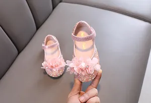Close-up detail of pink rhinestone princess shoes for girls with floral and pearl accents