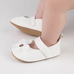 Detailansicht der eleganten weißen Baby-Lauflernschuhe verziert mit einer großen Stoffblume.