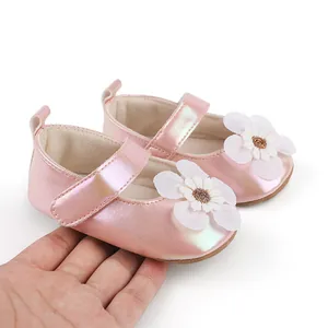 Detaillierte Nahaufnahme der rosa Babyschuhe mit weißer Stoffblume und Klettverschluss