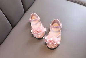 Detail view of pink glittery princess shoes for girls with 3D flower and bead accents.