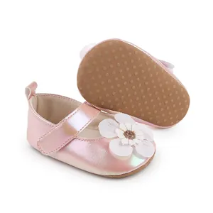 Detailansicht von perlmuttrosa Babyschuhen mit weißer Blume und rutschfester Sohle