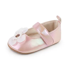Nahaufnahme eines rosa irisierenden Lauflernschuhs für Babys mit weißem Blumendetail