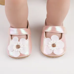 Detailansicht rosa schillernder Babylauflernschuhe mit einer weißen Blumendekoration