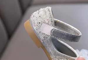 Close-up detail of silver sparkling girl's princess shoe with rhinestones and strap