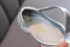 Close-up view of shimmering silver girls' princess shoe with gold insole logo detail