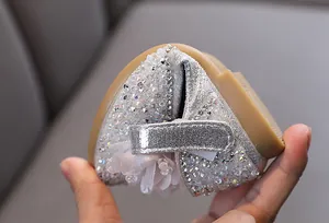 Close-up showing the flexible sole of silver rhinestone princess shoes for girls