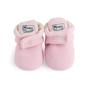 Macro detail of soft pink fleece baby winter boots showing Velcro closure and warm lining