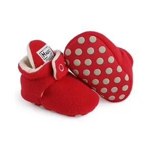 Close-up of red fleece winter baby booties with thick lining and non-slip dotted sole