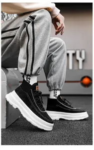 Close-up of stylish black high-top sneakers with chunky white platform soles for men.