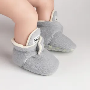 Close-up view of soft grey fleece baby booties with warm plush lining for winter