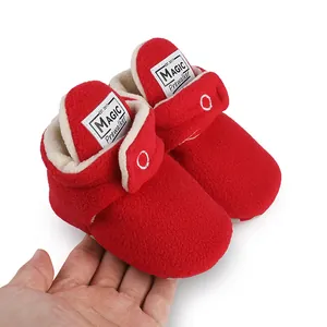 Close-up of red fleece baby prewalker booties with warm lining and brand label detail