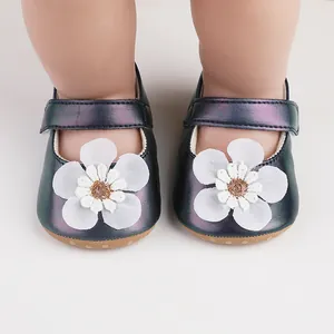 Detailansicht irisierender Lauflernschuhe für Babys mit weißer Blumendekoration oben.