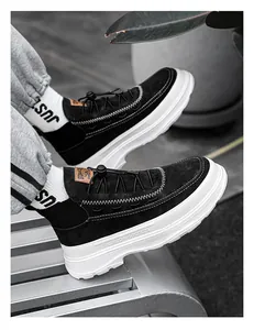 Close-up of black high-top platform sneakers with thick white soles on a metal bench