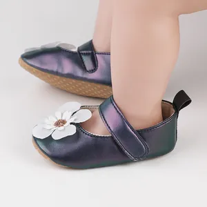 Nahaufnahme von schillernden Baby-Mary-Janes mit weißer Blume am Kleinkindfuß