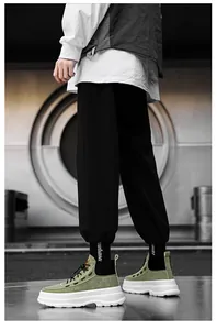 Side view of olive green high-top platform sneakers with thick white soles