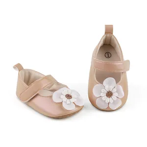 Detailansicht von metallisch-beigen Baby-Lernlaufschuhen mit weißer Blumenapplikation.