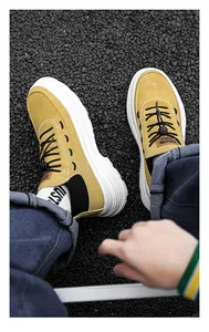 Close-up of yellow high-top platform casual shoes on asphalt ground