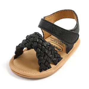 Detailweergave van zwarte gevlochten babysandalen met zachte zool en klittenbandsluiting