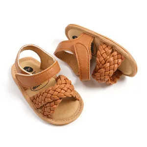 Detailoverzicht van gevlochten baby sandalen in bruin met zachte zolen en klittenband