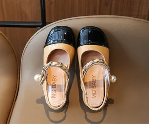 Top down view of girls patent leather Mary Jane shoes with pearl and chain accents