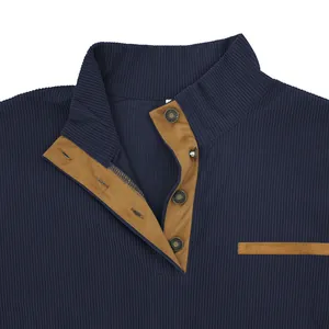 Close-up of navy blue corduroy sweatshirt featuring a brown trim stand collar and snaps.