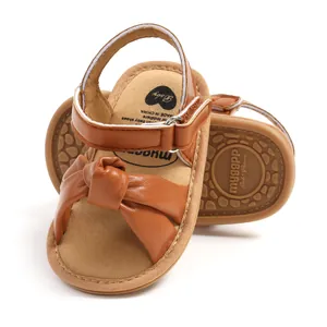Detailopname van bruine babysandalen met strik en antislip zachte zool voor de zomer