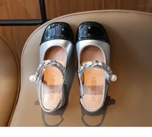 Detail view showing silver girls' Mary Jane shoes with pearl strap and black toe.
