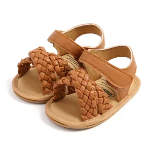 Detail van bruine gevlochten baby sandalen met zachte zool en klittenbandsluiting.