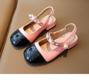 Detail view of pink girls' patent leather sandals with black toe cap and pearl charm