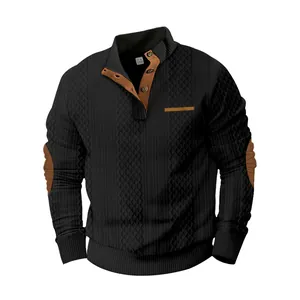 Detalle de sudadera jacquard negra para hombre con cuello y coderas de gamuza marrón.