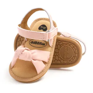 Detail van de roze babysandalen met een zachte zool en een elegant strikontwerp