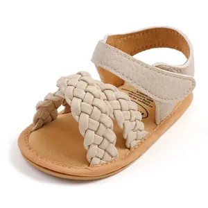 Detail van beige gevlochten babysandalen met zachte textuur en klittenbandsluiting