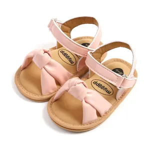 Close-up van roze baby sandalen met zachte zool en decoratieve strik voor meisjes