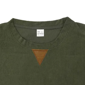 Close-up detail of a men's green corduroy crewneck sweatshirt showing fabric texture.