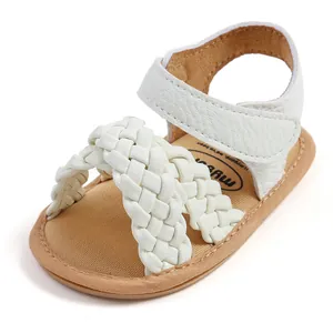 Detailweergave van witte gevlochten babysandalen met verstelbare klittenbandsluiting en zachte zool