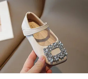 Close-up of girl's patent leather princess shoe with sparkling rhinestone buckle.