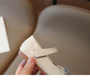 Detailed macro view of beige patent leather girl's princess shoe with strap