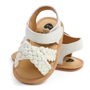 Detailopname van witte gevlochten babysandalen met zachte zolen en klittenbandsluiting