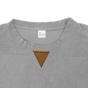 Close-up of grey corduroy sweatshirt neckline with size L polyester tag.