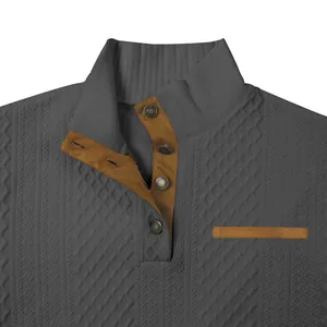 Detalle de sudadera de jacquard gris con ribete de ante marrón y botones de presión