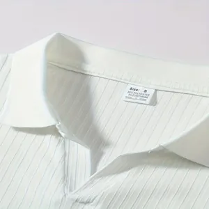 Detailopname van een gestreepte polokraag met een polyester maattabel en waslabel