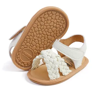 Gedetailleerd overzicht van gevlochten witte babysandalen met antislip rubberen zool.