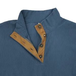 Gros plan du col montant avec patte en daim contrastée sur sweat-shirt bleu côtelé