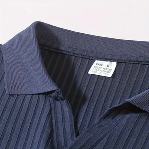 Detail van de marineblauwe geribbelde polokraag met maat S-label en stofsamenstelling.