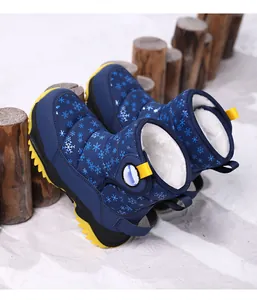 Dettaglio di scarponi da neve blu per bambini con fiocchi di neve e calda fodera in pelo.