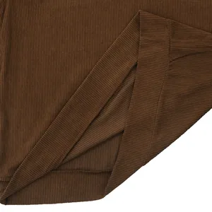 Macro detail of brown corduroy sweatshirt fabric showing ribbed texture and hem stitching